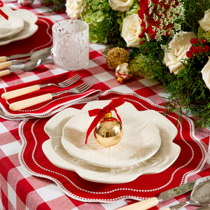 Red scalloped placemat with pearl detail and white embroidery on red buffalo check tablecloth with bordallo pinheiro beige cabbage plates festive christmas tablescape in red